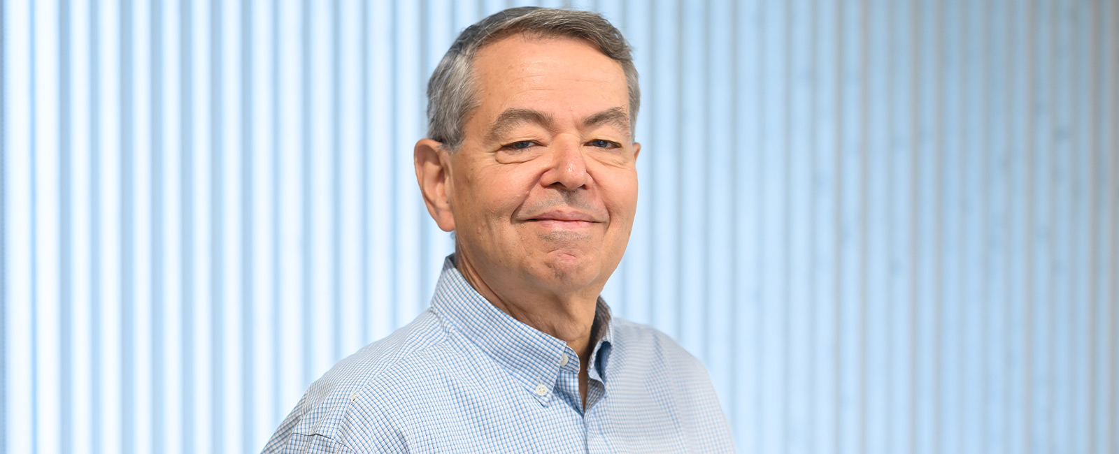 Professor Steve Buchwald smiles in front of a blue background.