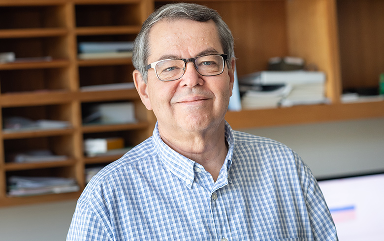 Professor Steve Buchwald smiles in his office.