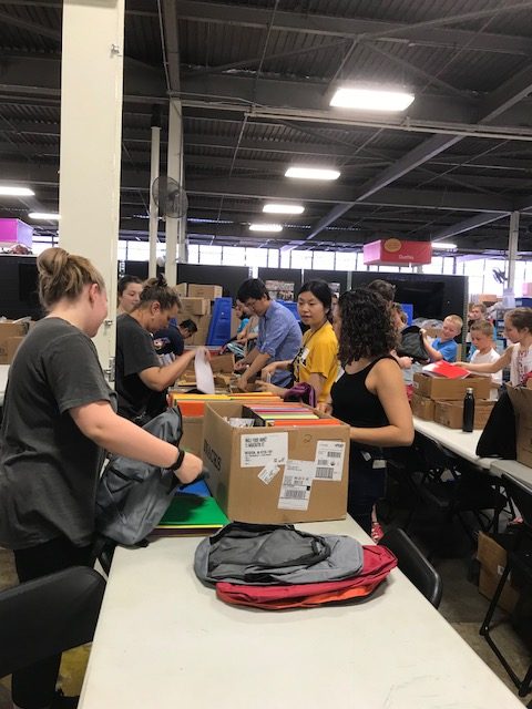 Members from the Department of Chemistry help assemble backpacks for Cradles to Crayons recipients.