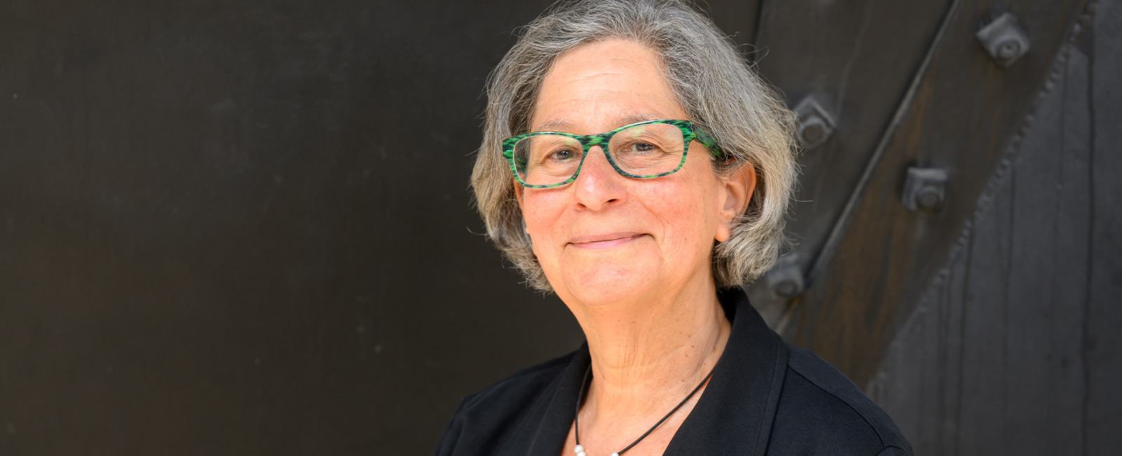 Professor Susan Solomon smiles in front of a dark background.