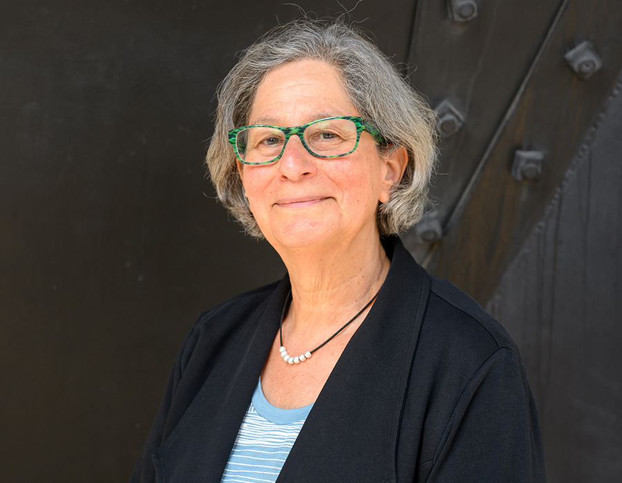 Professor Susan Solomon smiles in front of a dark background.