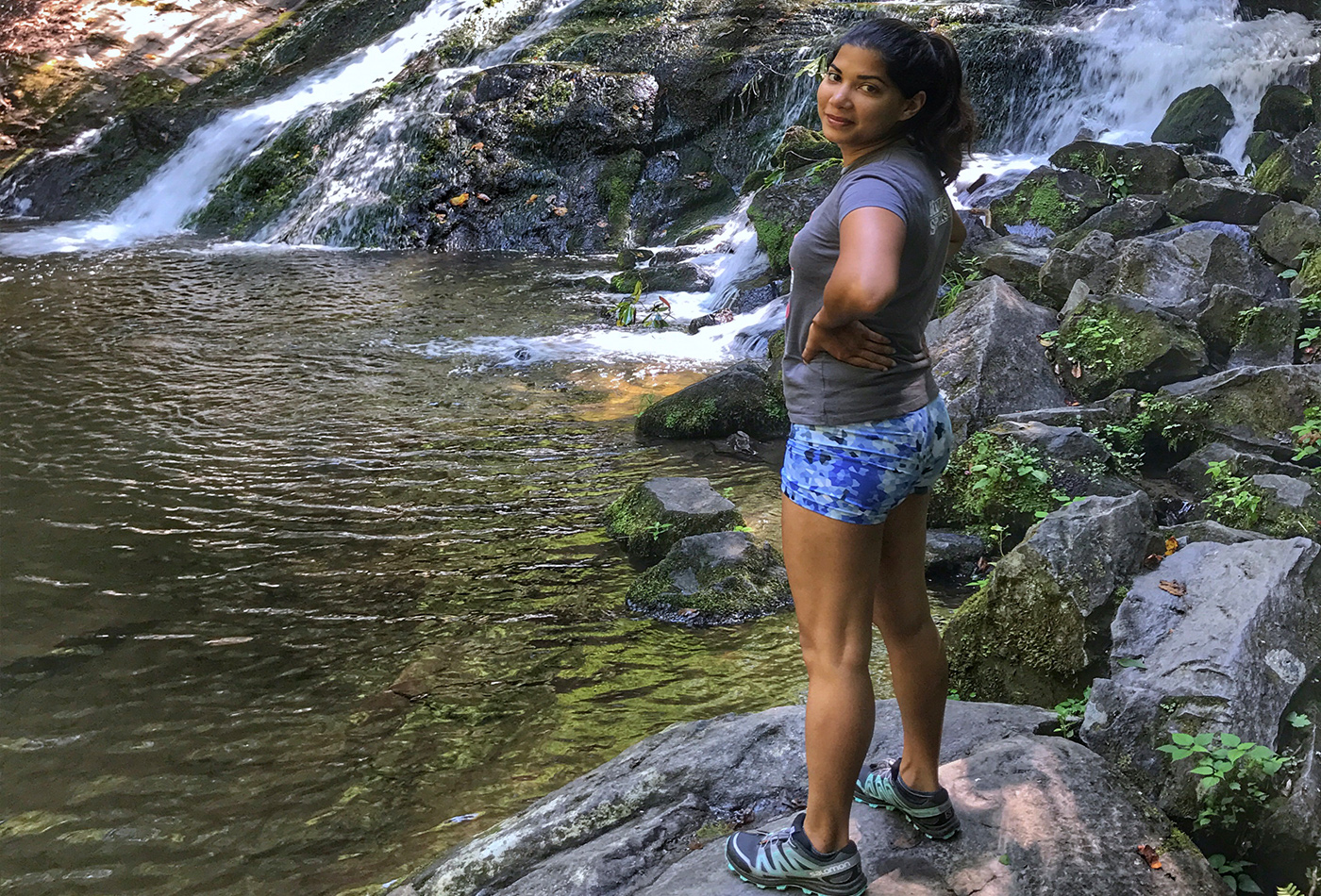 Lisa Cunden stands beside a waterfall