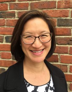 Katherine Lee stands in front of a brick wall