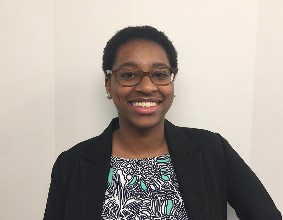 A female undergraduate chemistry major poses in front of a wall.