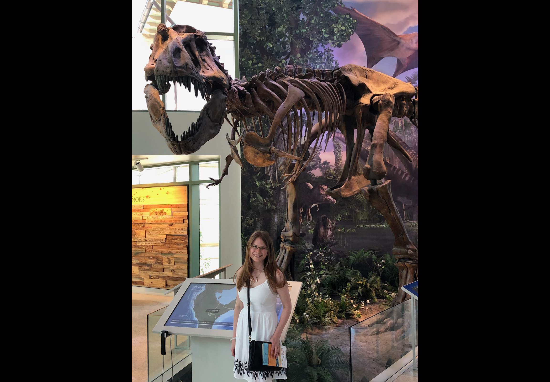 Nicole Moody poses before a T-Rex Skeleton