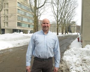 Scott Ide smiles with building 18 in the background