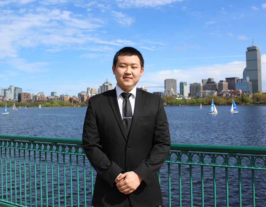 Undergraduate Chemistry Major Miller Tan poses in front of the Boston skyline