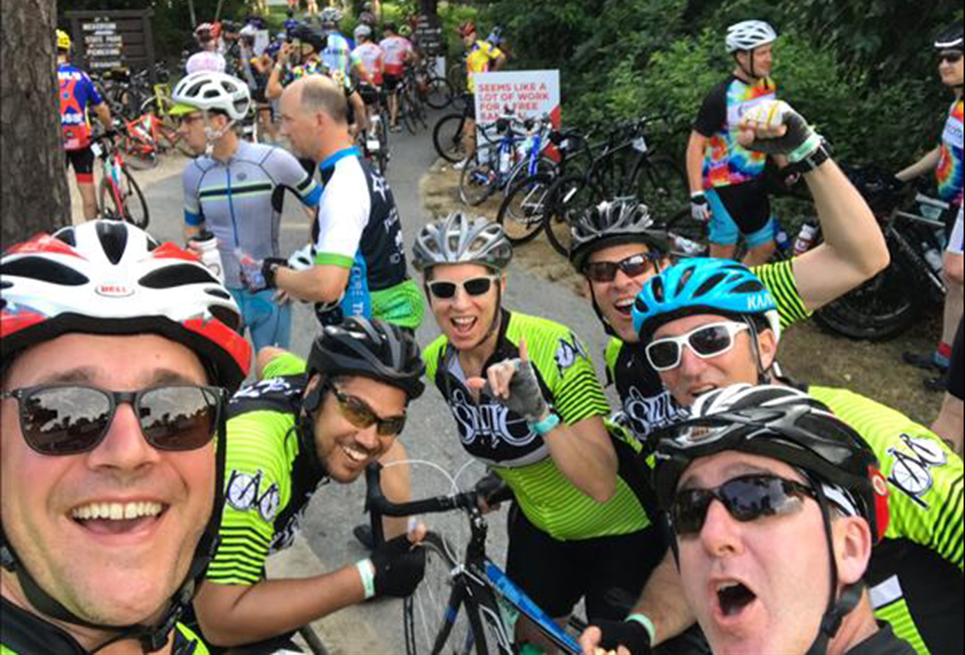 A team of bicyclists pose for a selfie while on the road.