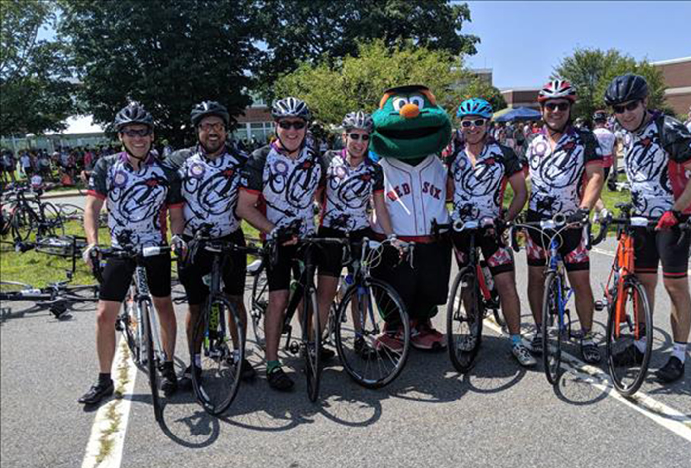 A team of bicyclists pose with the Red Sox mascot.