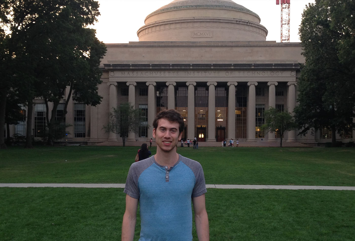 A man stands in front of the MIT dome.
