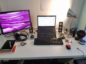 A work from home space with two monitors and a keyboard.