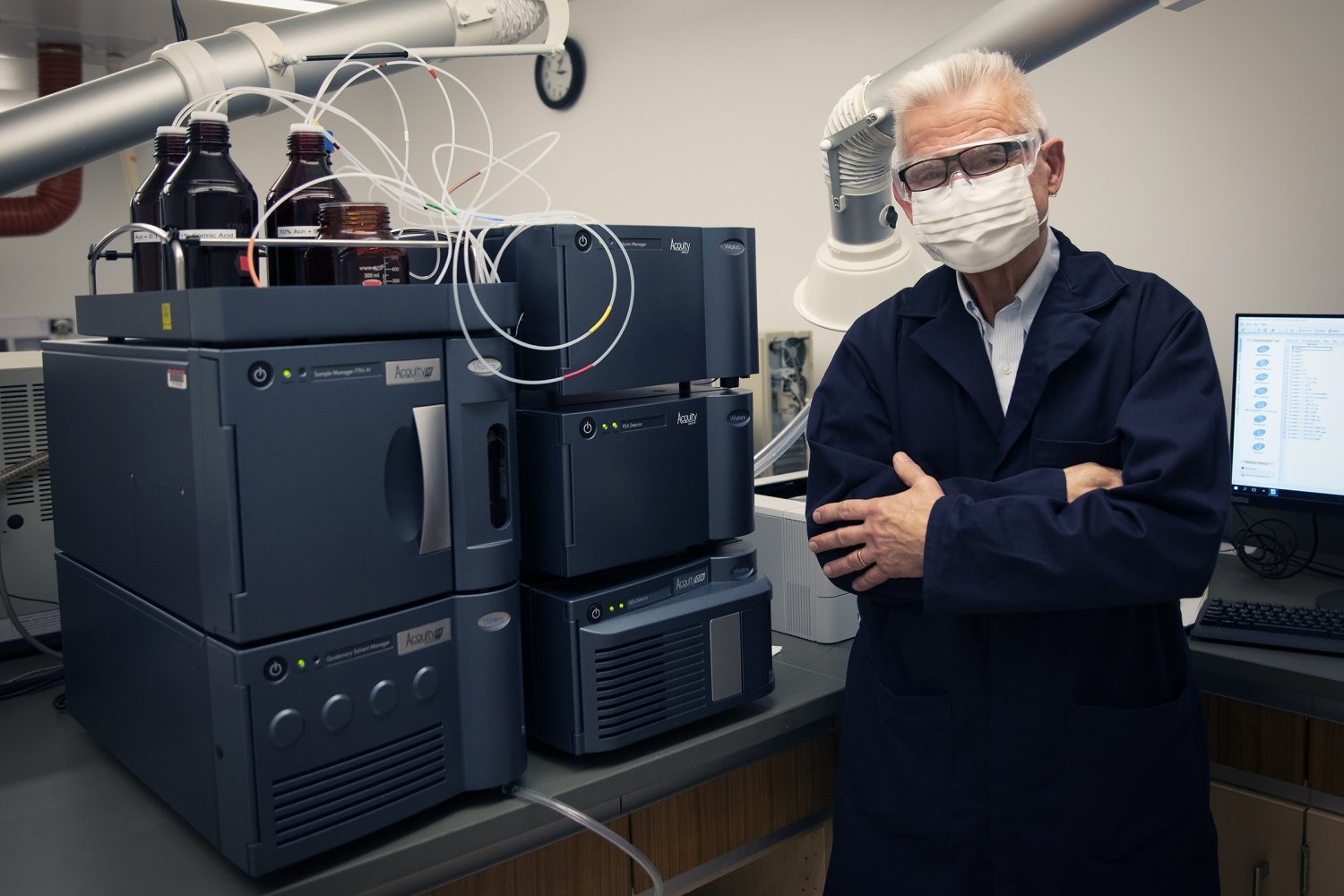 A man stands in front of a mass spectrometer.