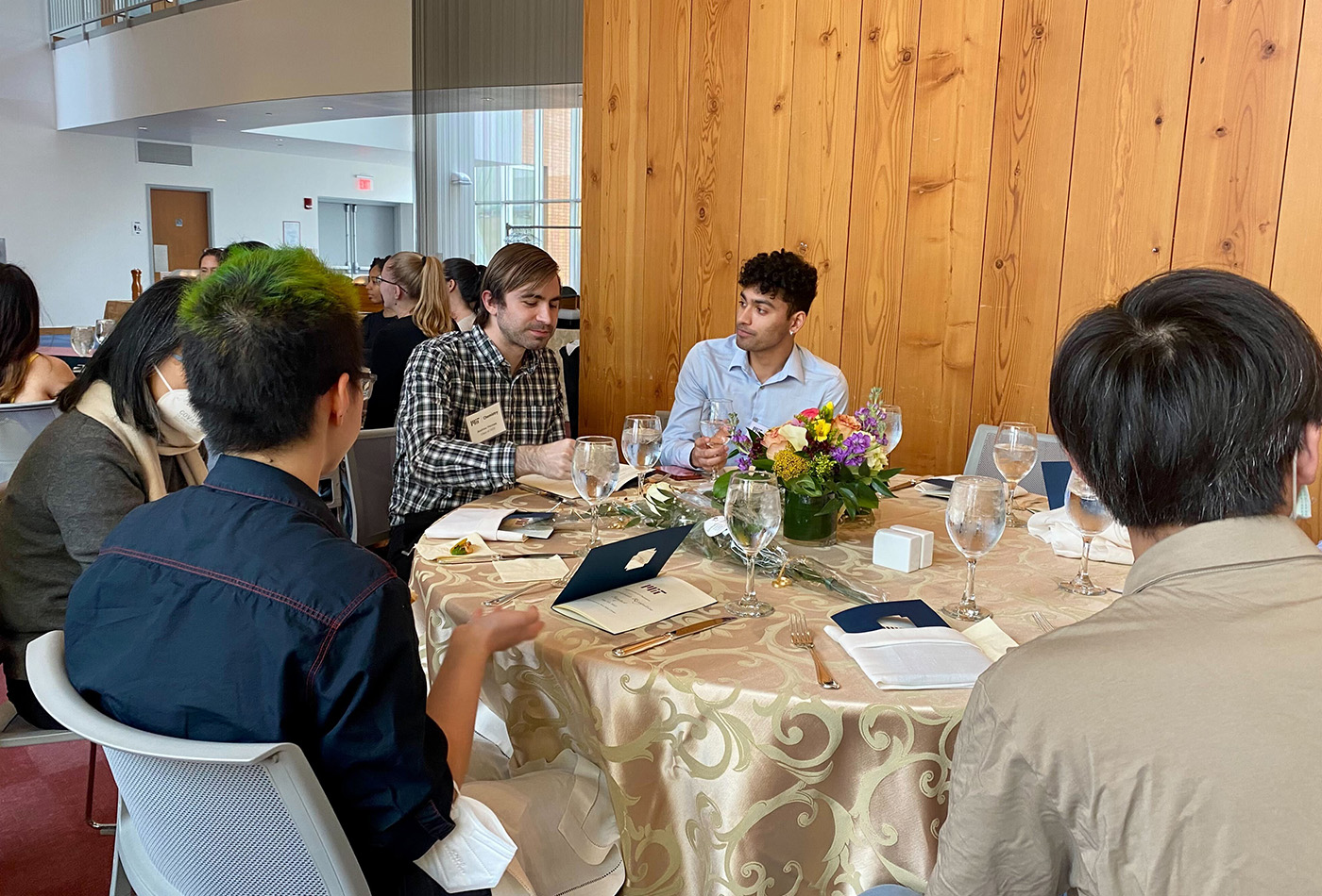A group of students and faculty sit at a table.