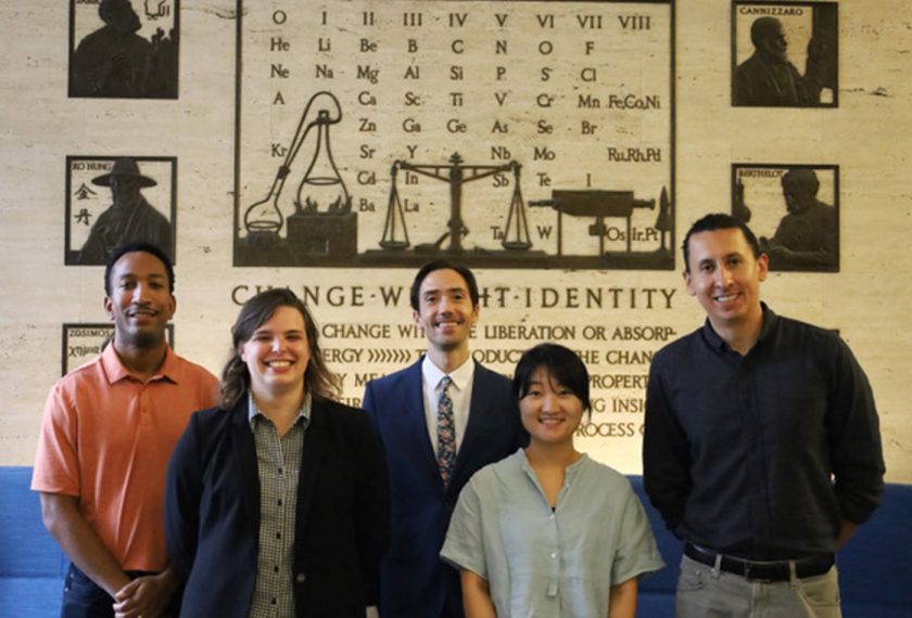 Four postdoctoral researchers stand together and smile.