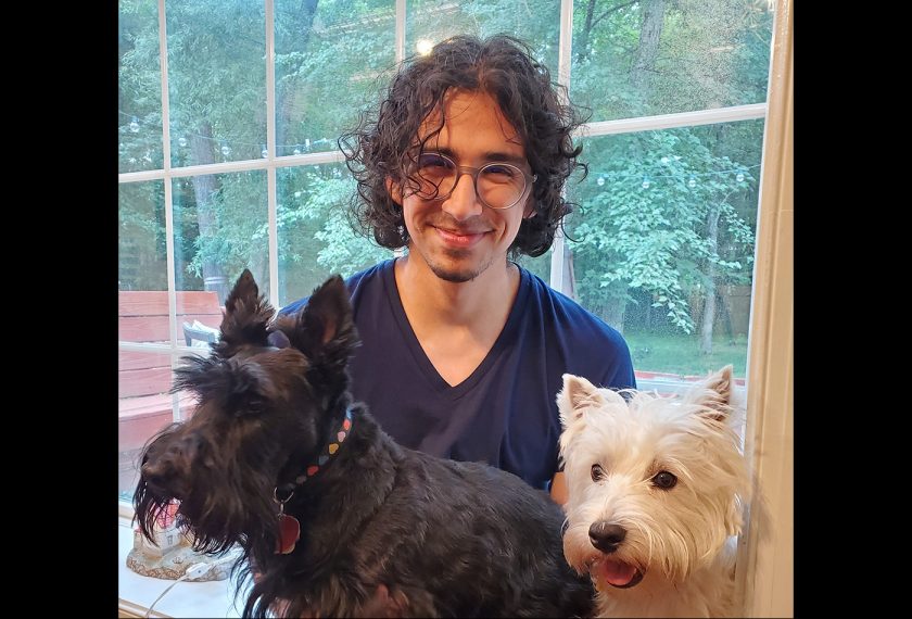 Justin Airas smiles with a Scottish terrier and a Westie terrier.