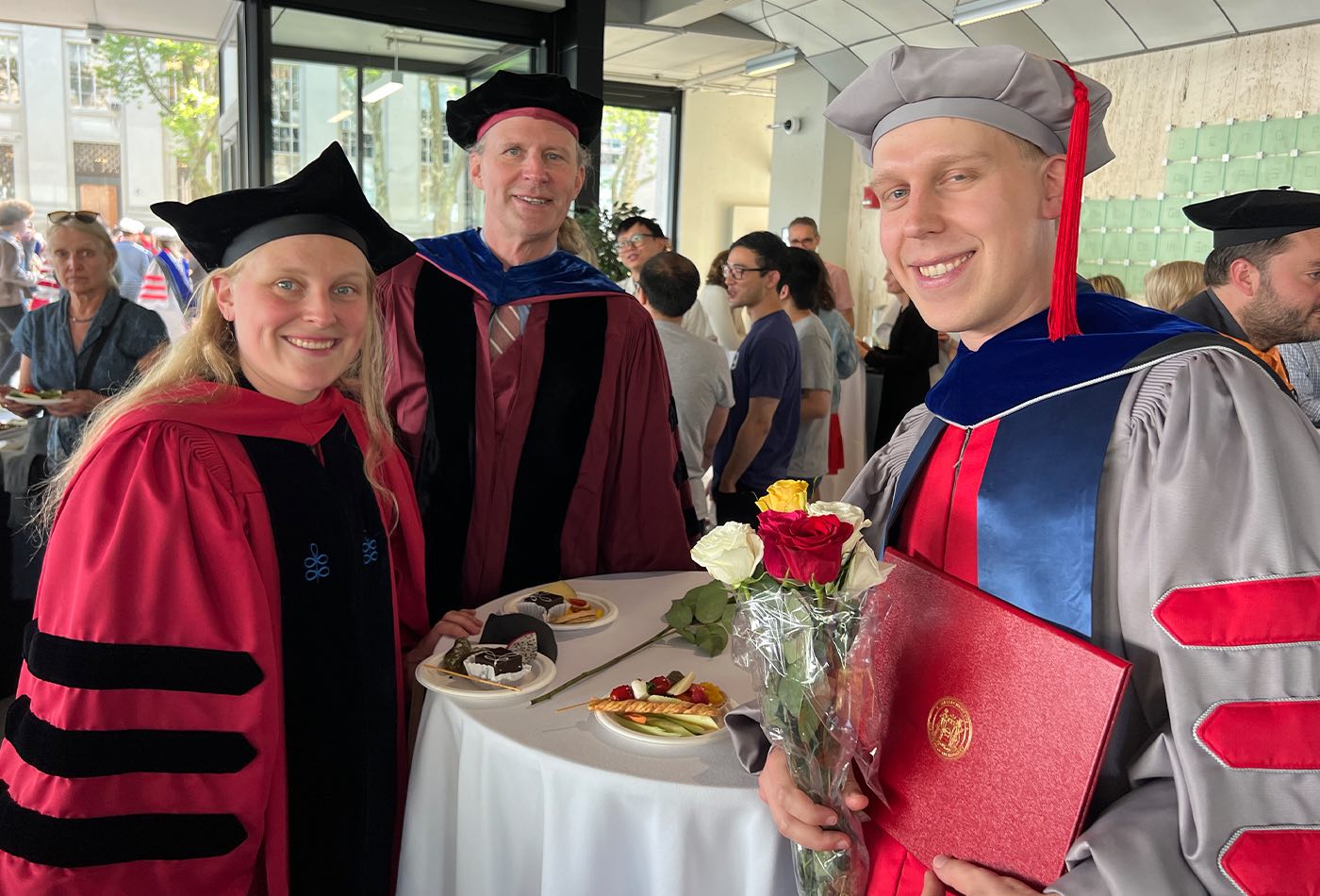 Cole Perkinson and his guests, all in PhD regalia, enjoy refreshments at the reception.