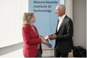 Sally Kornbluth and Moungi Bawendi stand facing each other in front of sign that says "Massachusetts Institute of Technology"