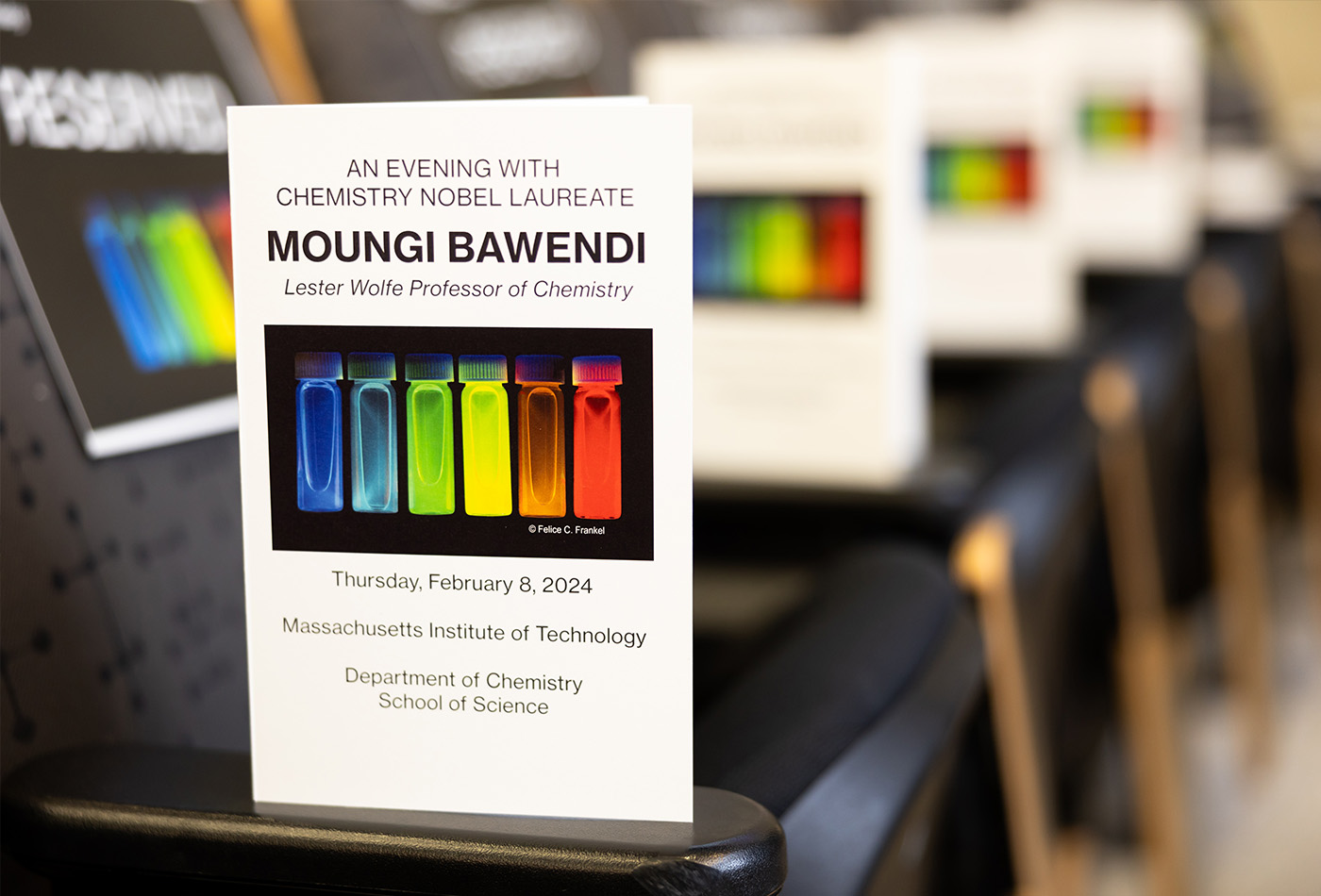 A program reads AN EVENING WITH CHEMISTRY NOBEL LAUREATE MOUNGI BAWENDI and features a colorful photo of quantum dots in six small vials.