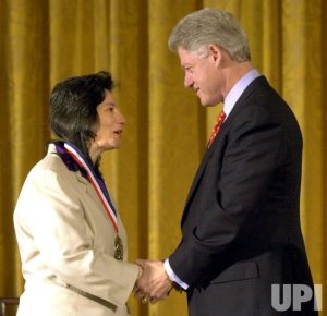 Professor Susan Solomon receives a gold medal on a red, white, and blue ribbon from President Bill Clinton.