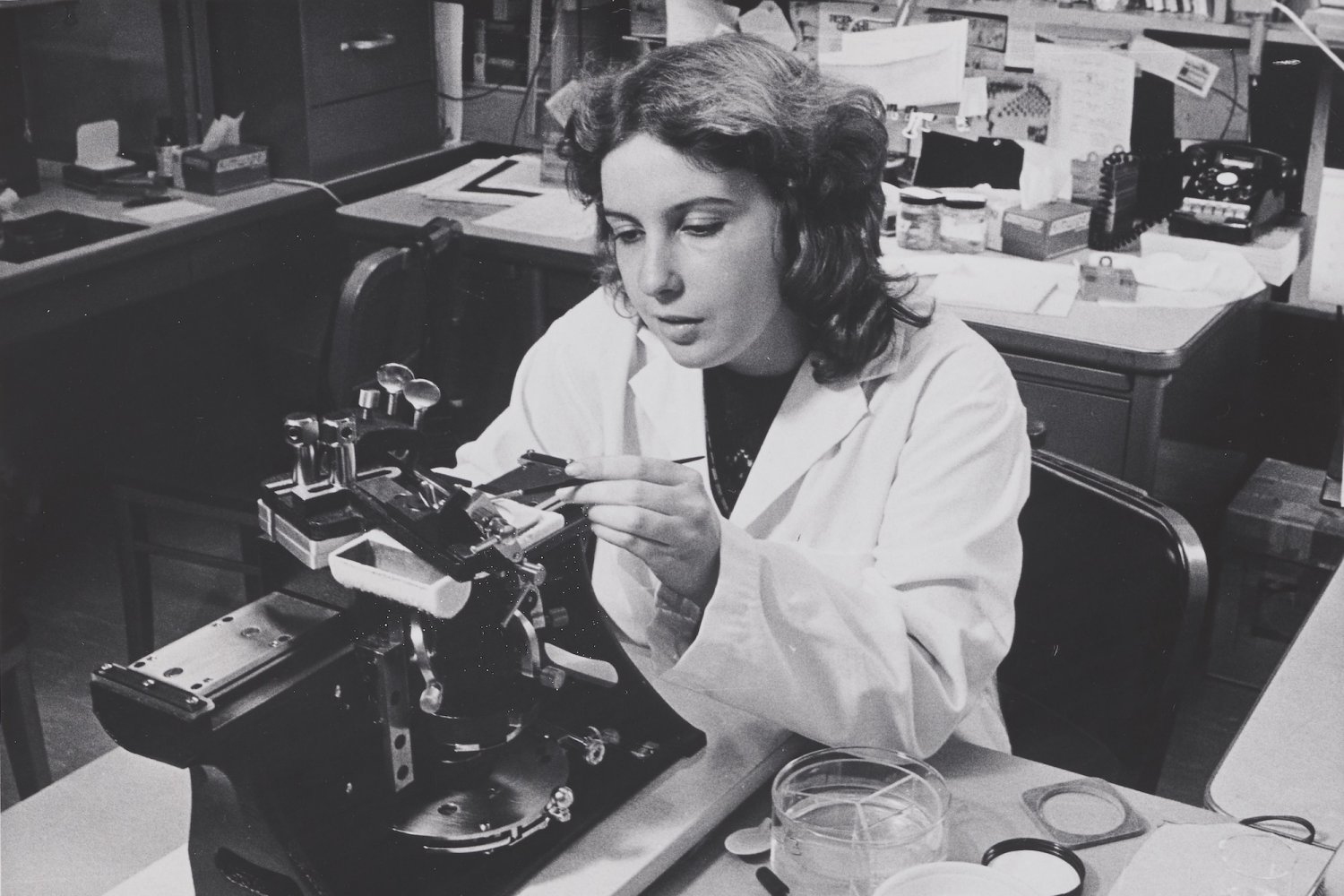 Anne Serby works in a lab setting in 1980 as depicted in a black and white photo.