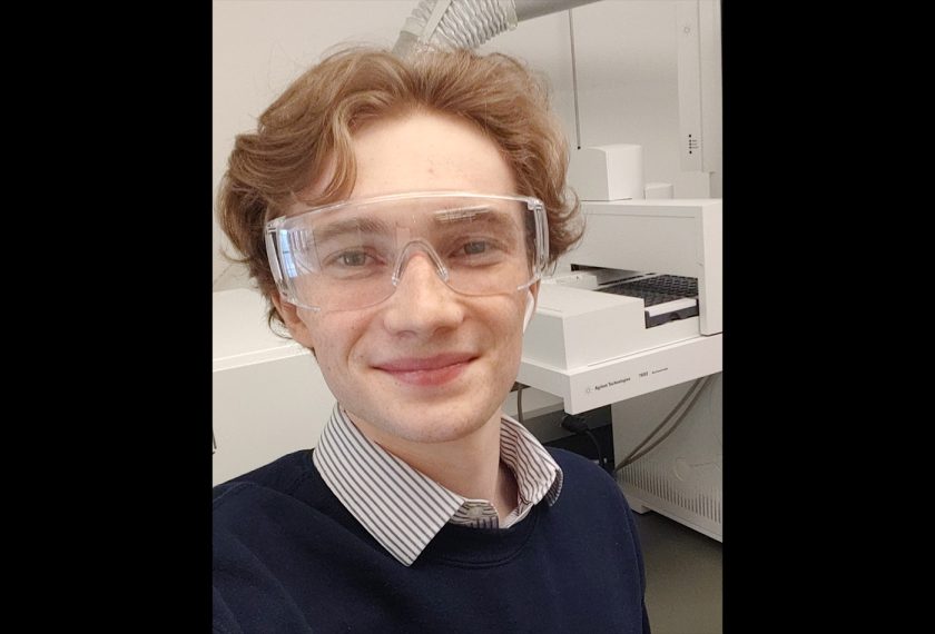 Reuben Allen wears protective eyewear and smiles in the lab.