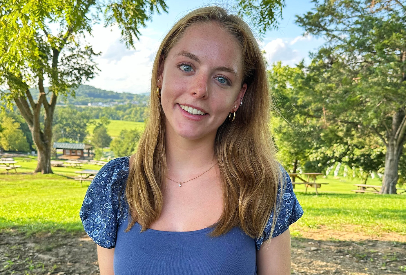 Catherine Hazard smiles in a sunny vineyard.