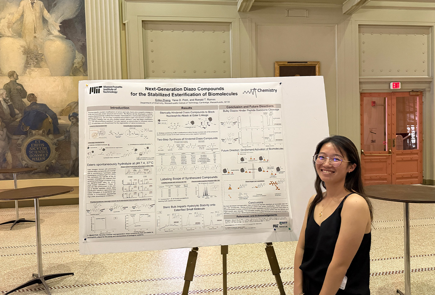 Erika Zhang stands in front of a poster.