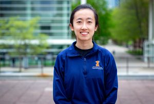 Anh Nguyen smiles in an outdoor urban setting.