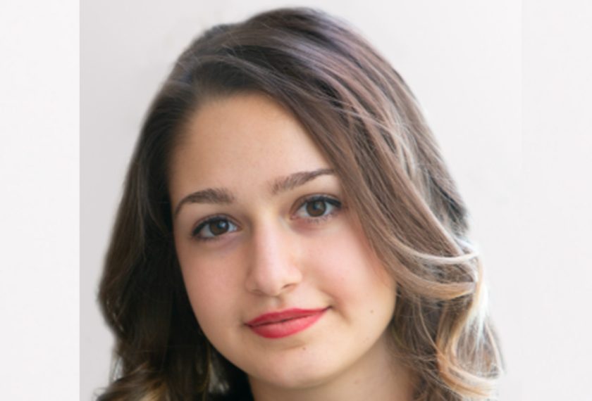 Georgia Voyiatzis smiles in front of a white background