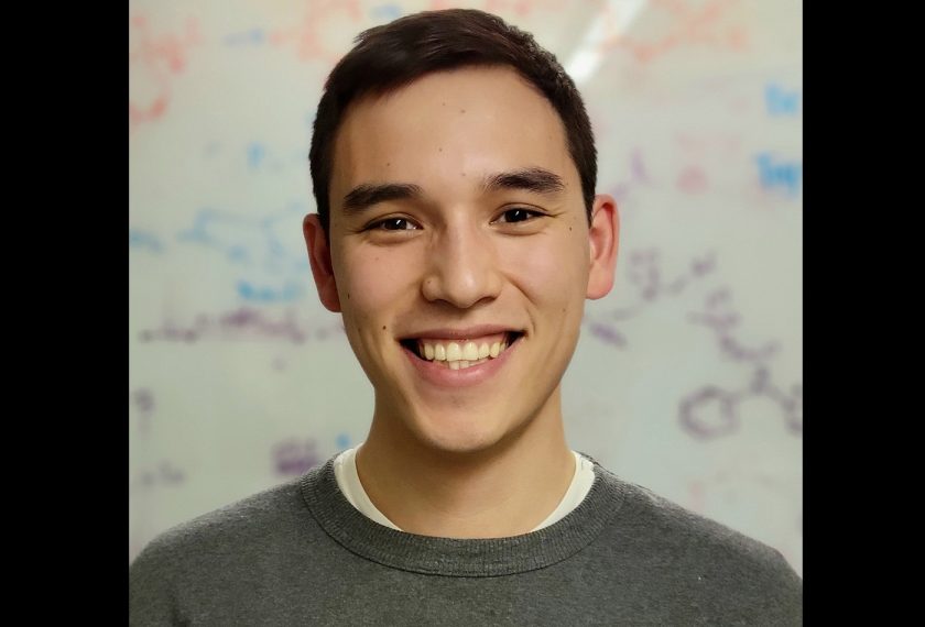 Jonas Rein smiles in front of a white board.