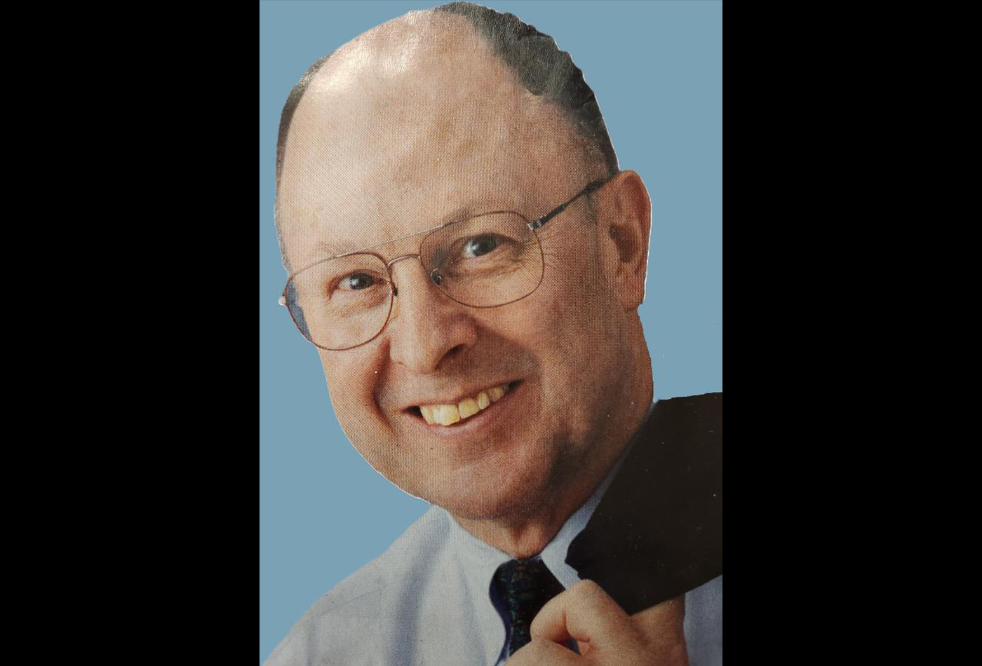 Charles Casey smiles in front of a blue background