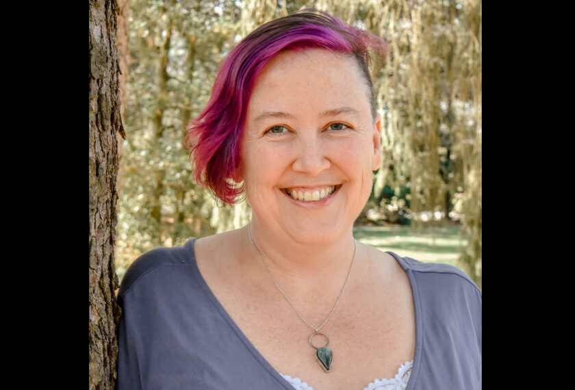 Meg Fuchs smiles in an outdoor setting.