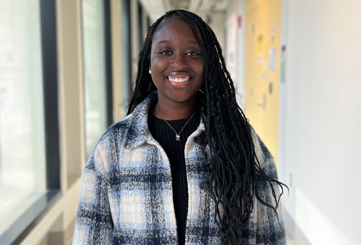 Ekua Beneman smiles in a hallway.