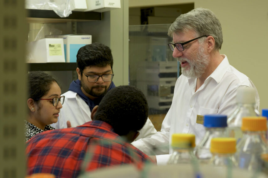 Simon Friedman works in a lab with three graduate students.