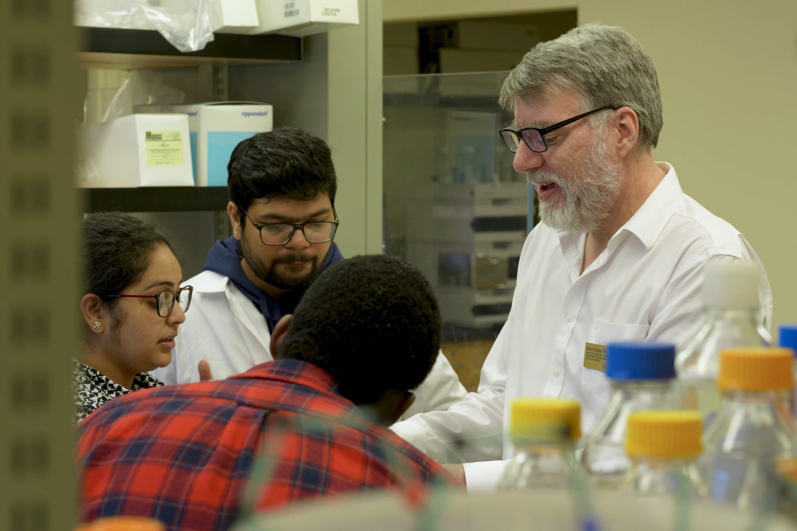 Simon Friedman works in a lab with three graduate students.