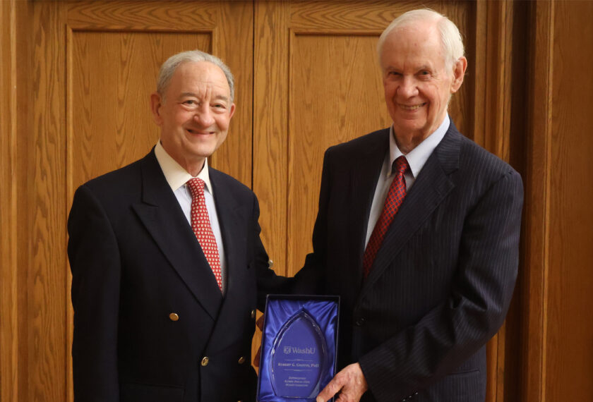 Bob Griffin smiles beside Mark Wrighton while holding his distinguished alumni award.