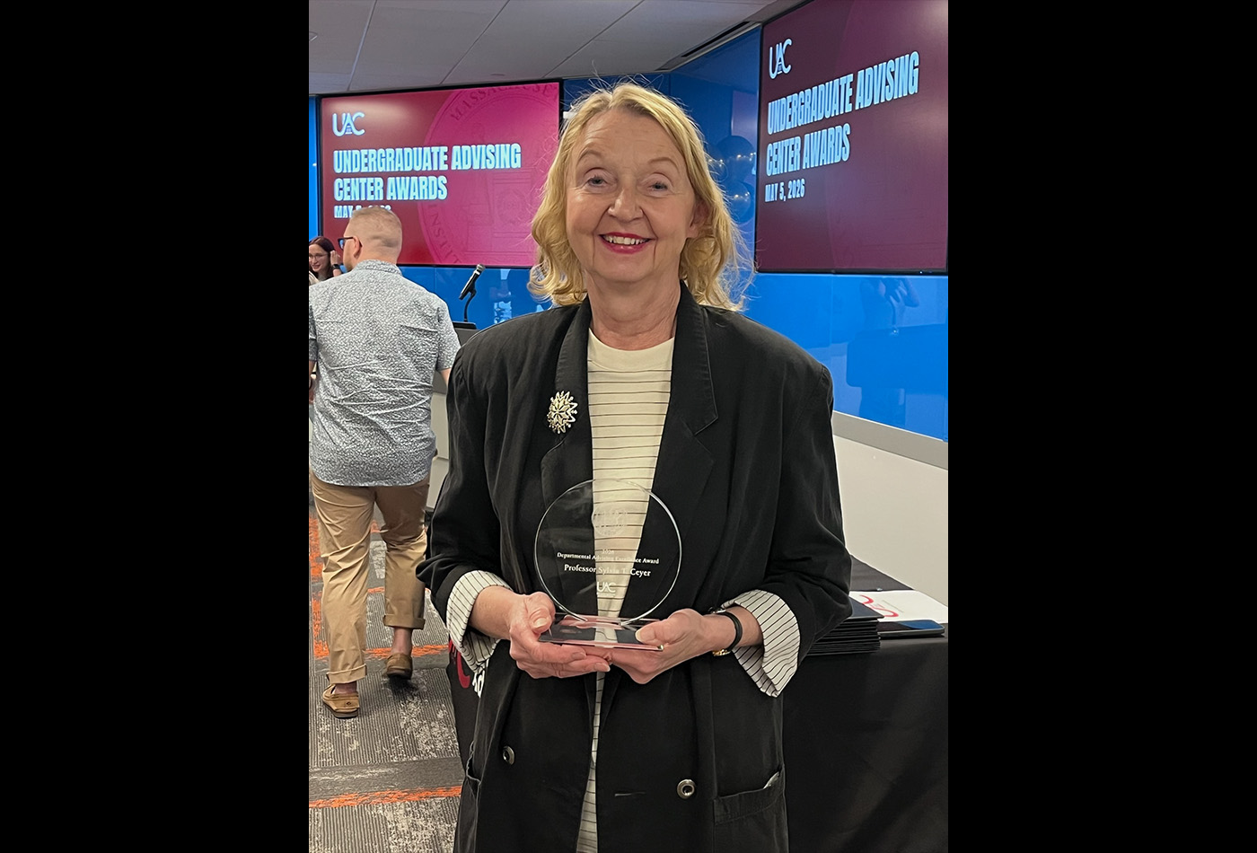 Sylvia Ceyer smiles holding her award.