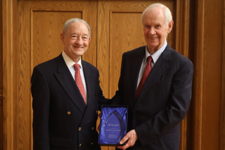 Bob Griffin smiles beside Mark Wrighton while holding his distinguished alumni award.