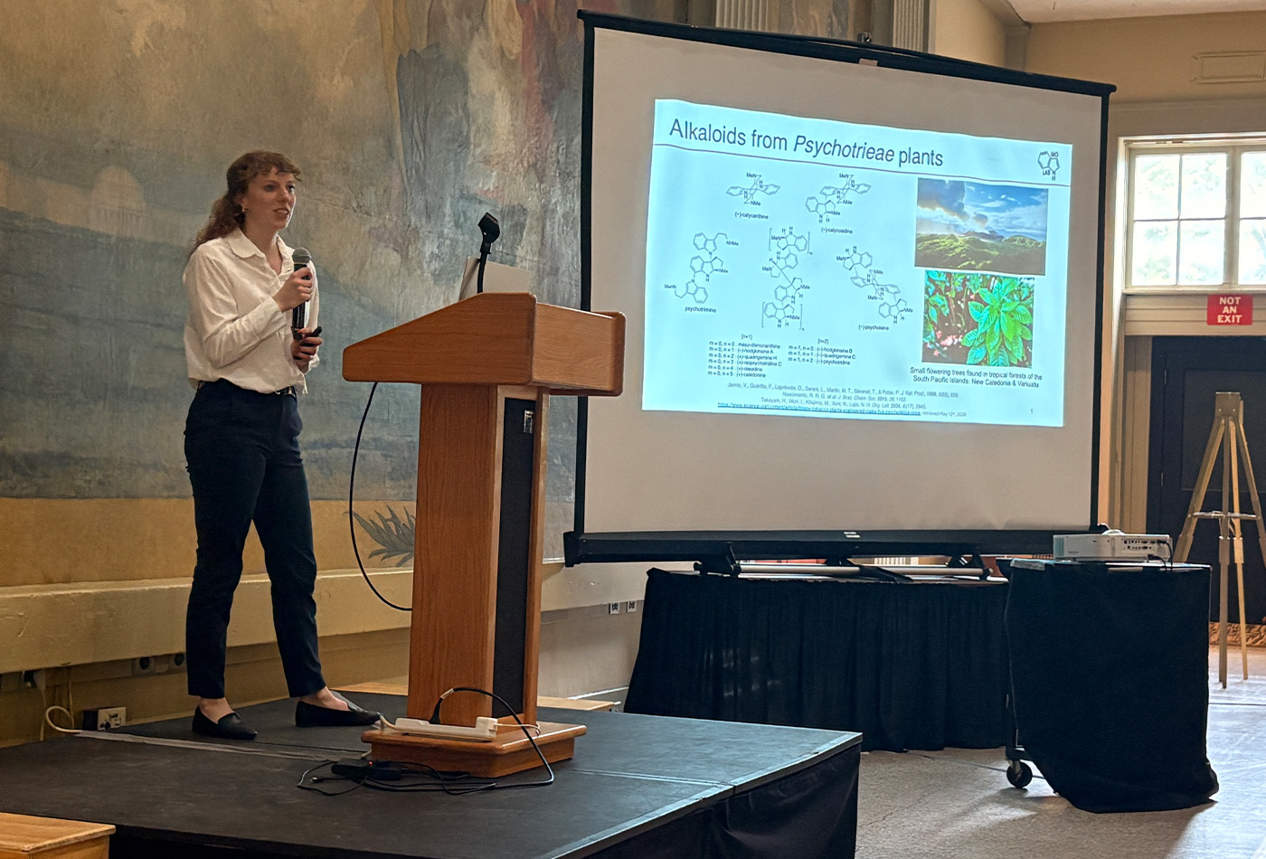 Kathleen Downey stands in front of a power point presentation.