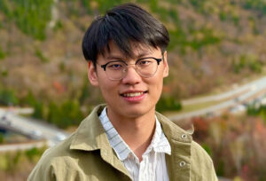 Yuzhe Wang smiles in an outdoor setting.